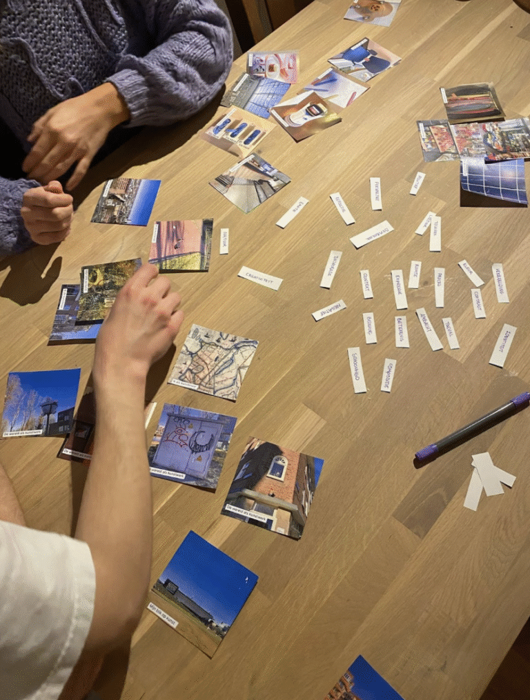 Participants seated at a table, interacting with printed photos and a worksheet containing descriptive words, as part of the Photo Profile exercise.